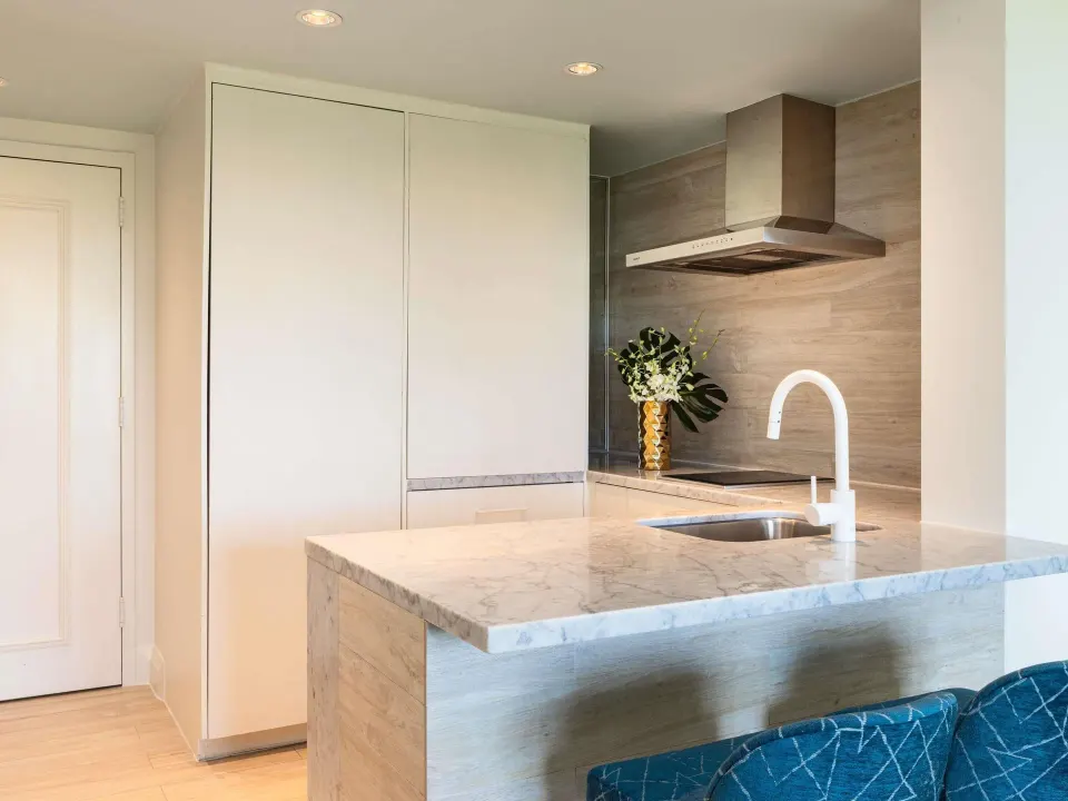 Superior Suite kitchenette with marble counter, sink, and cooktop at SLS Baha Mar.