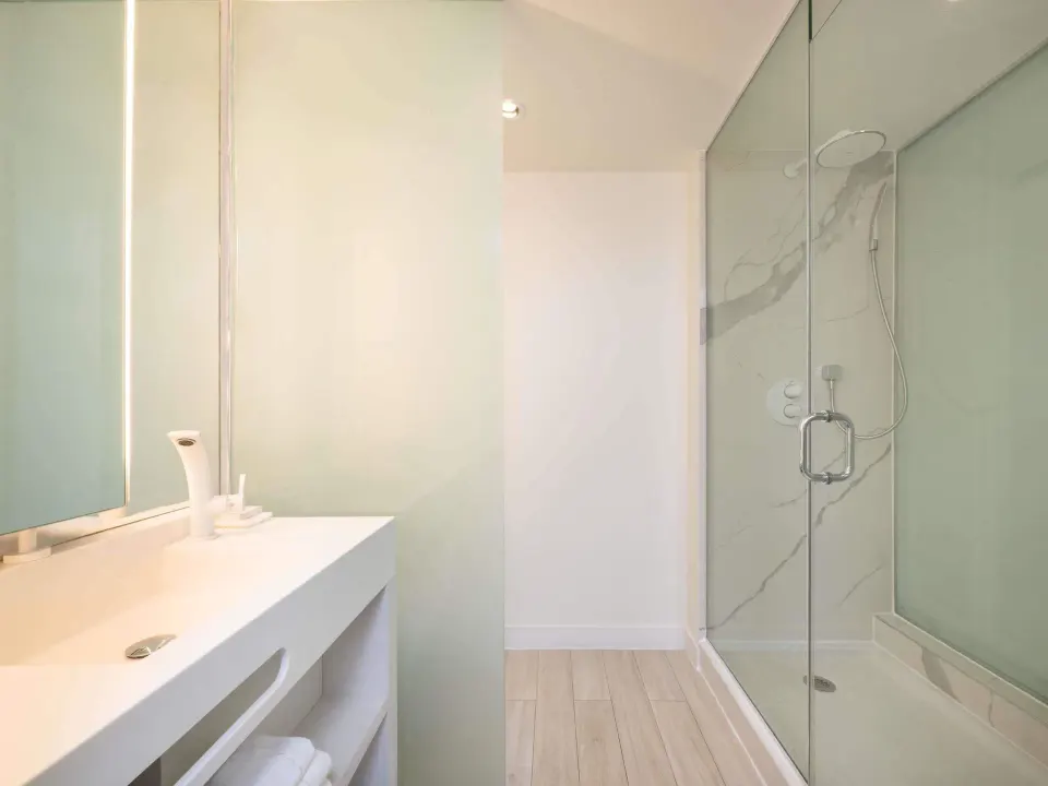 Superior room bathroom with vanity and glass shower at SLS Baha Mar.
