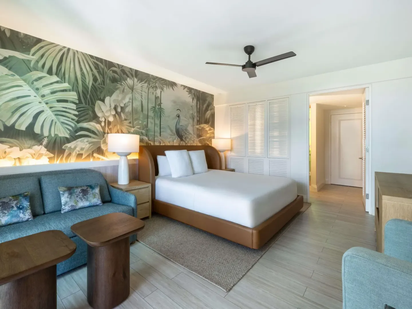 Superior king room with sofa, tropical mural, and bed at SLS Baha Mar.