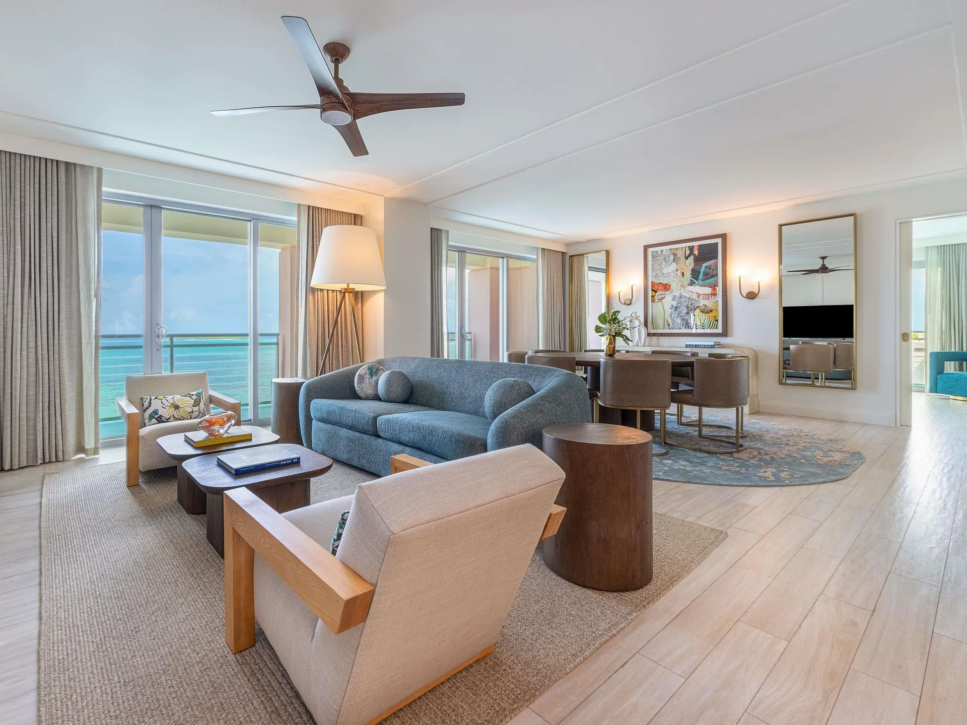 Living and dining area in a Three Bedroom SLS Baha Mar at SLS Baha Mar with ocean-facing glass doors.