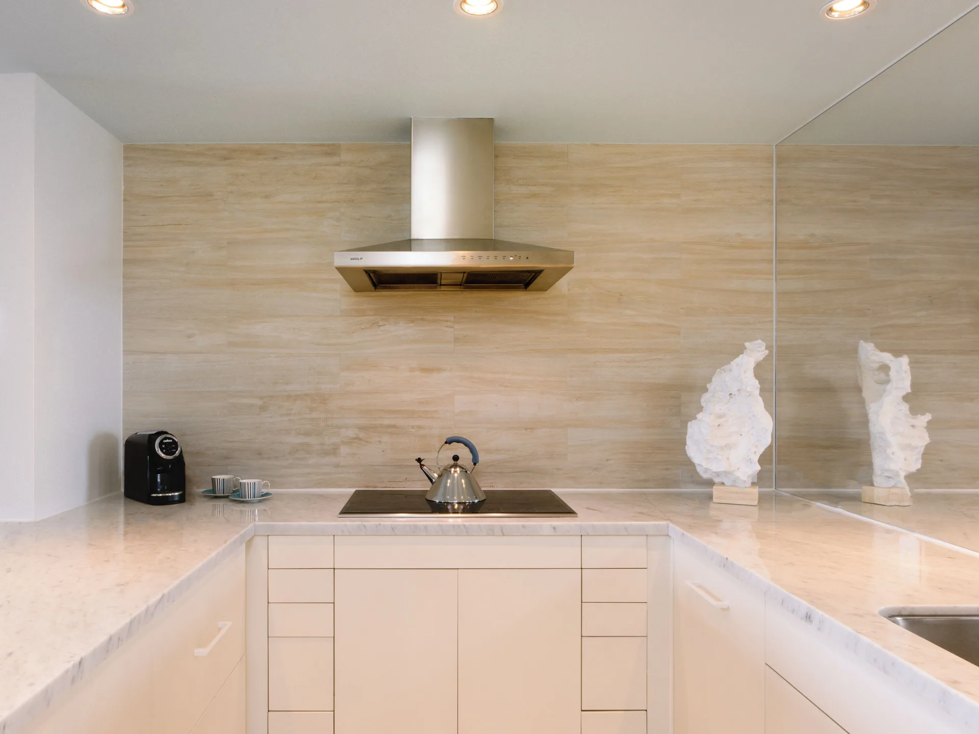 Kitchenette in a Three Bedroom SLS Baha Mar at SLS Baha Mar with cooktop, hood, kettle, and sink.