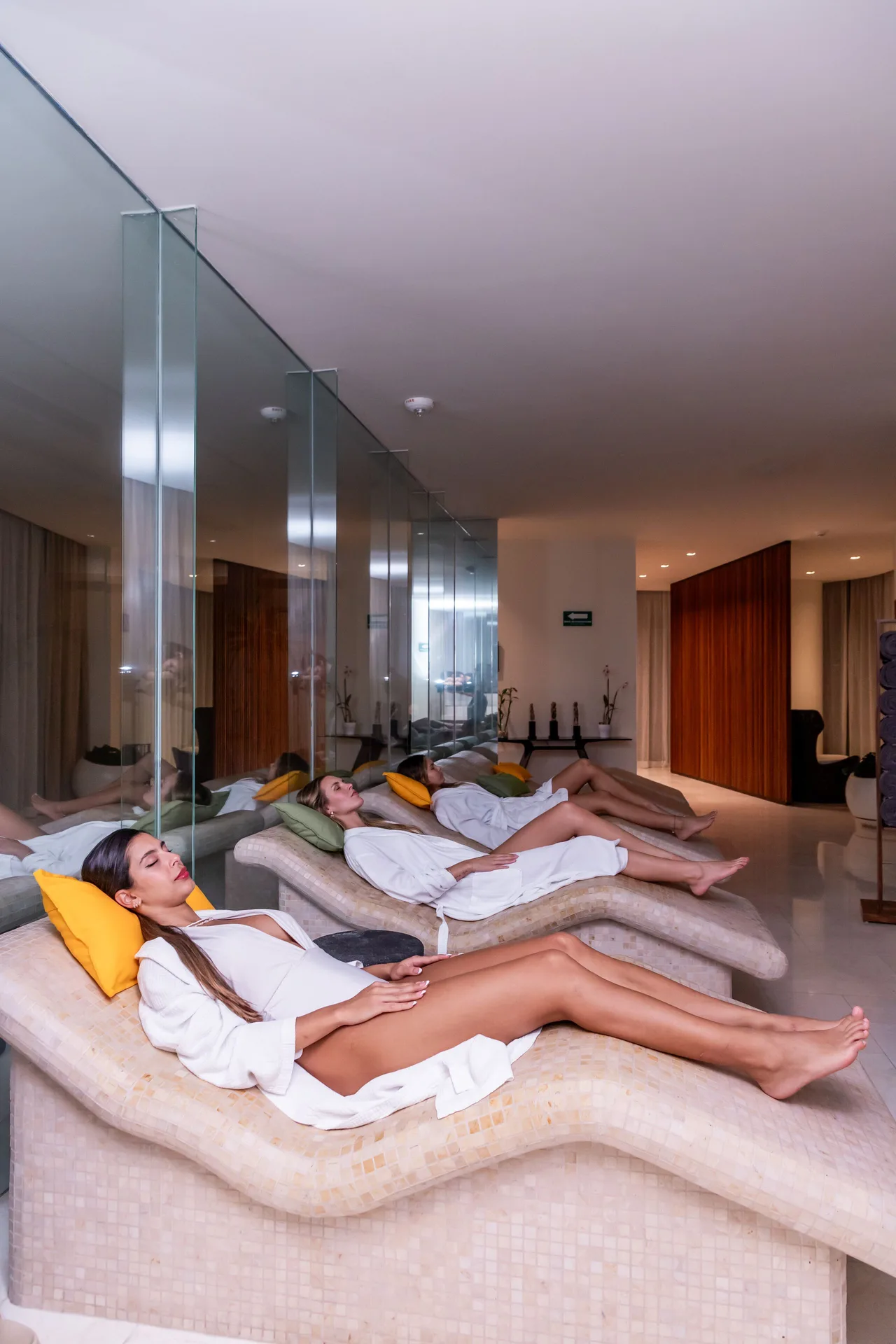 Spa relaxation room with guests reclining on heated loungers at SLS Cancun.
