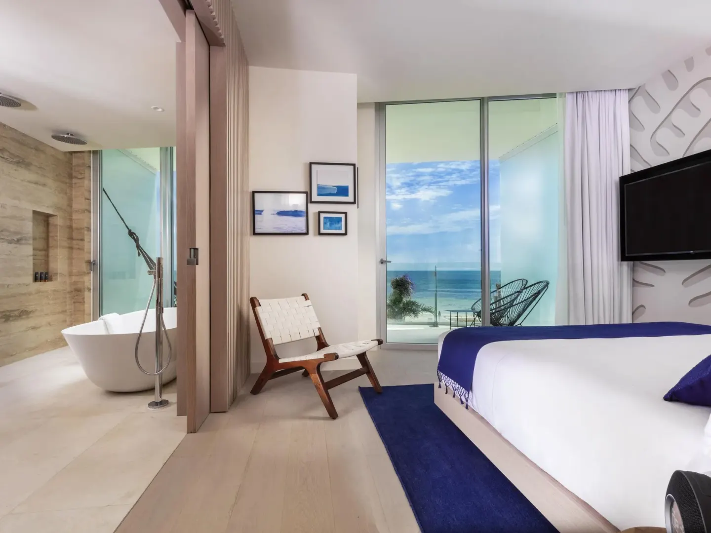 Deluxe Room Oceanfront at SLS Cancun with king bed, balcony view and freestanding tub.