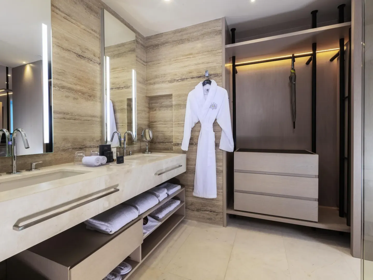 Deluxe oceanfront suite bathroom vanity and open closet with robe at SLS Cancun.
