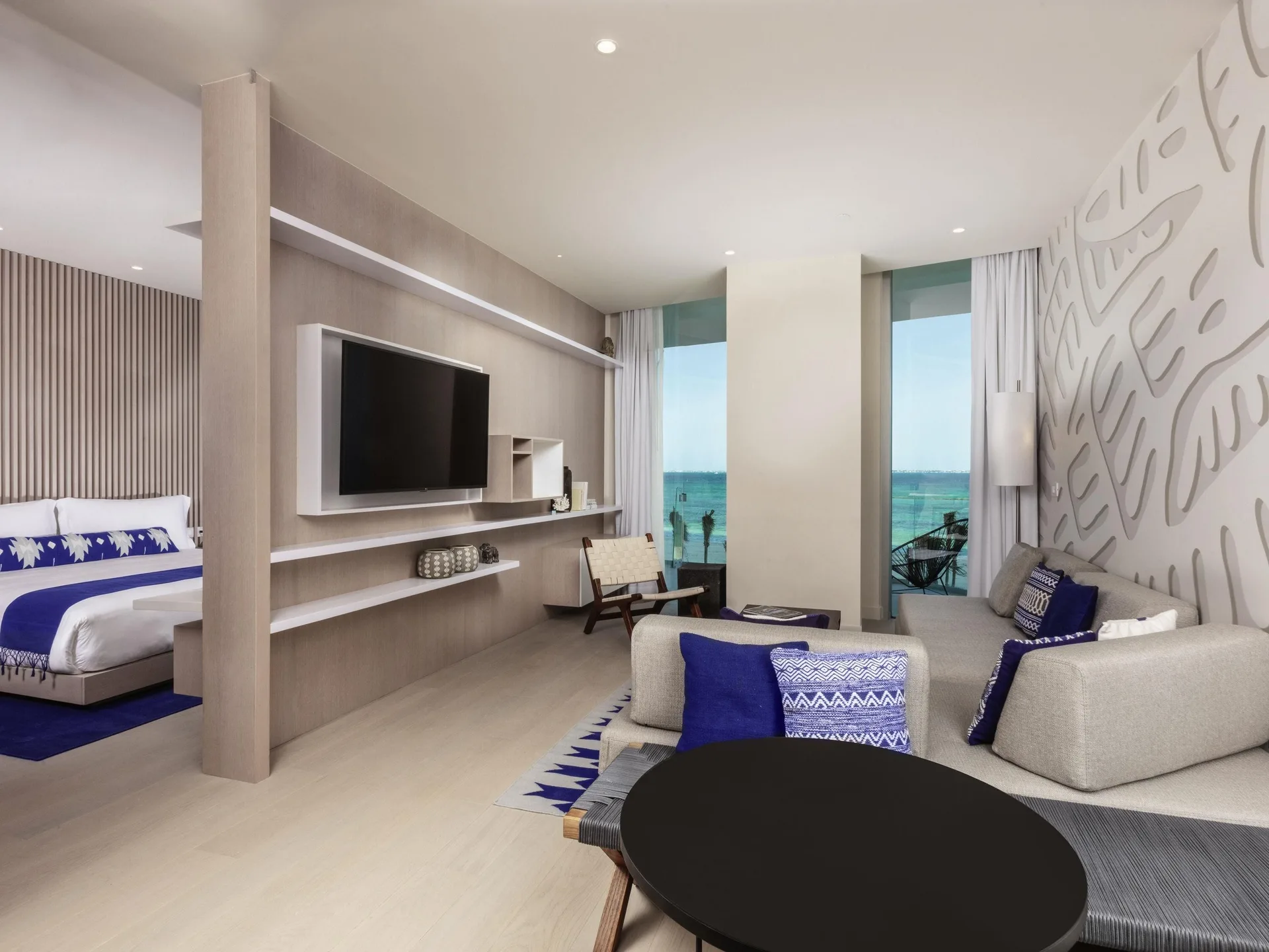 Premier Suite living area and king bed with oceanfront balcony at SLS Cancun.