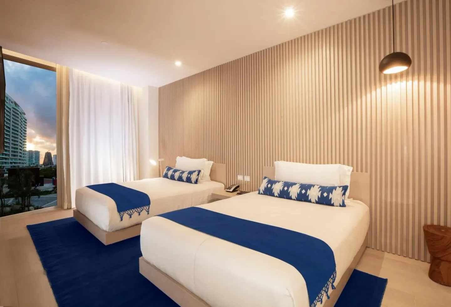 Superior Street View room with two beds beside a full-height window at SLS Cancun.