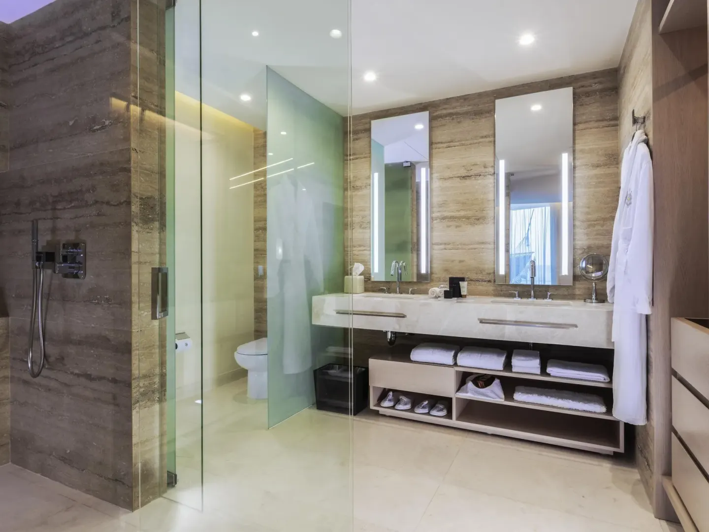 Superior Room bathroom with glass shower, double vanity, mirrors, robes, and towels at SLS Cancun.