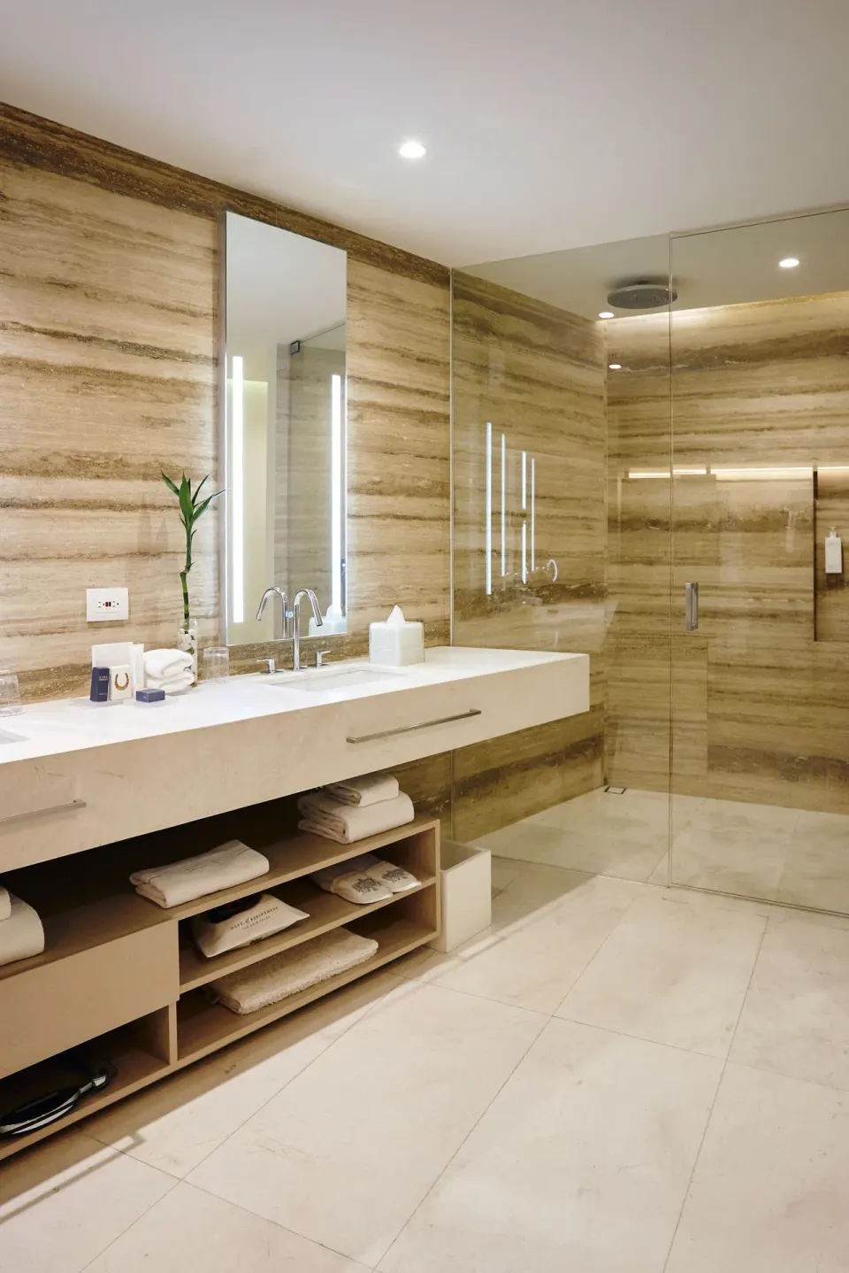 Superior Room bathroom with long vanity, lit mirrors and glass shower at SLS Cancun.