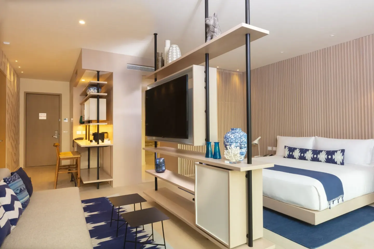 Superior Room with king bed, sofa, TV divider, and entry vanity at SLS Cancun.