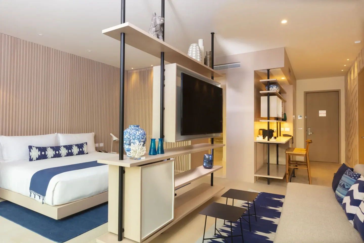 Superior Room with king bed, sofa, TV shelving, and vanity area at SLS Cancun.
