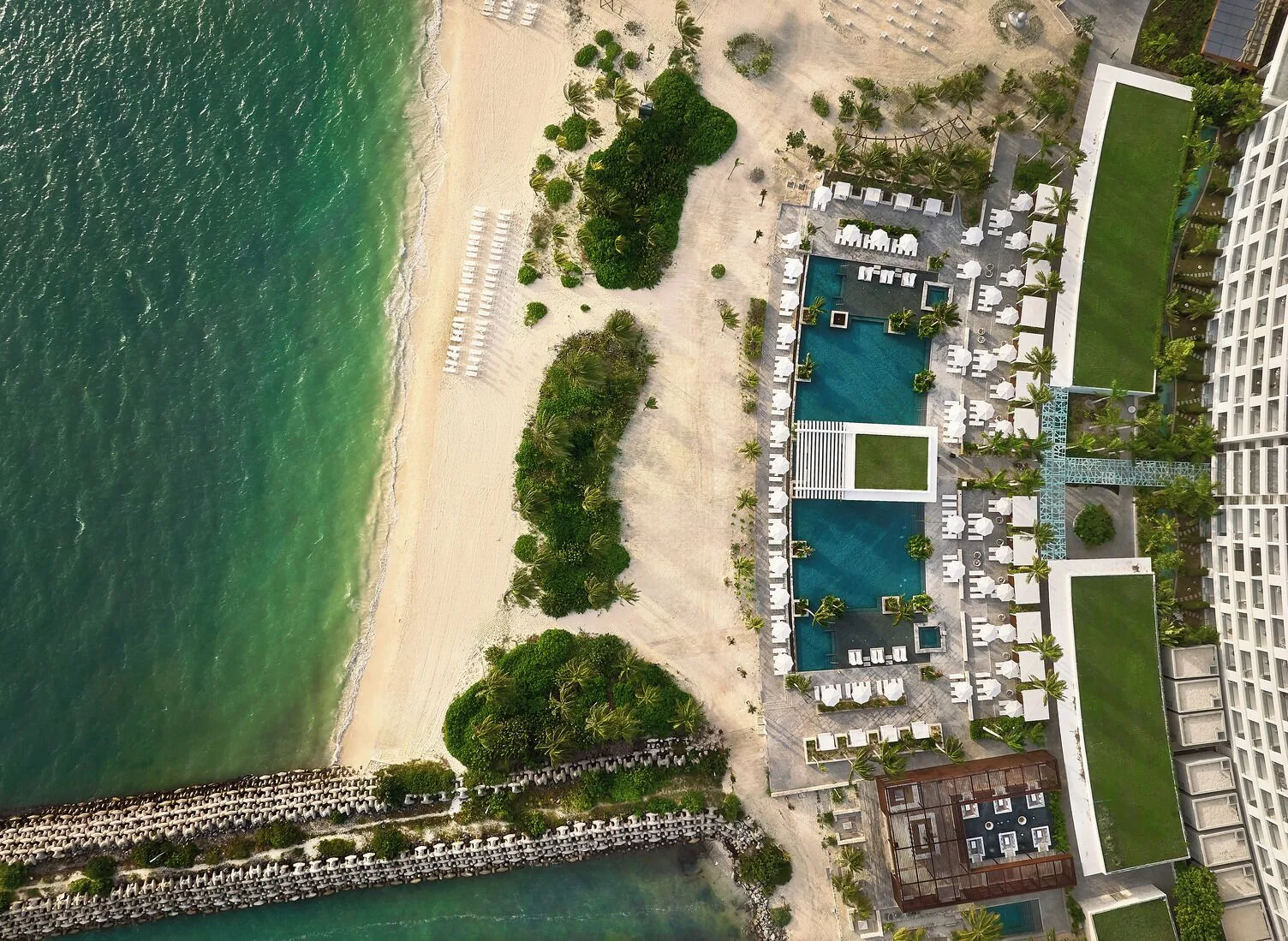 Aerial view of the beach, pools and resort building at SLS Playa Mujeres.