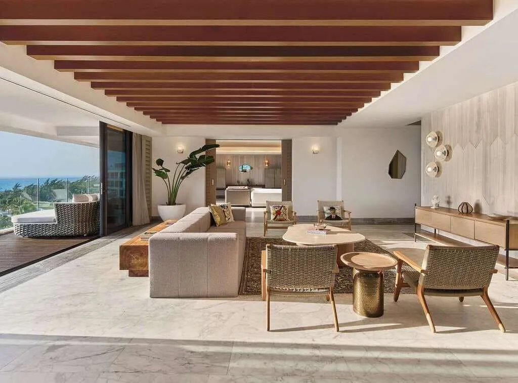 Spacious suite living room with balcony and ocean view at SLS Playa Mujeres.