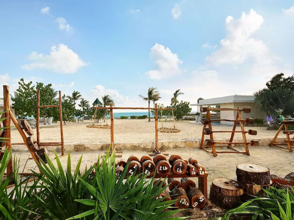 Outdoor fitness area with wooden weights and sandy grounds at SLS Playa Mujeres.