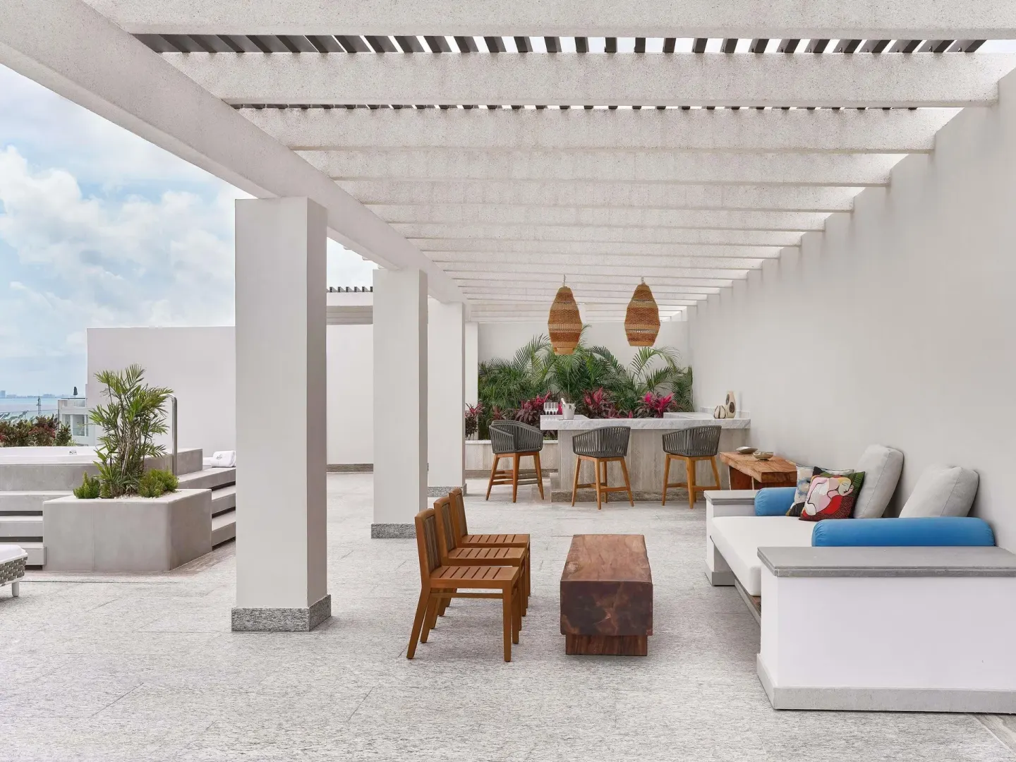 Rooftop terrace lounge with bar seating at SLS Playa Mujeres.