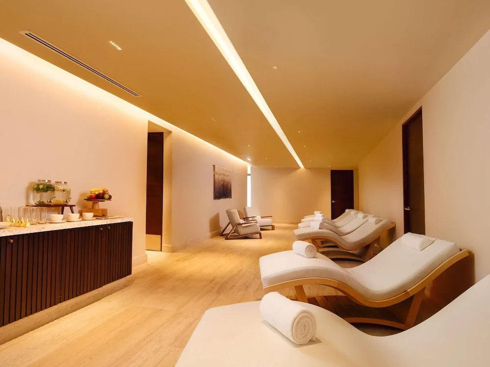 Spa relaxation lounge with chaise loungers and refreshments at SLS Playa Mujeres.
