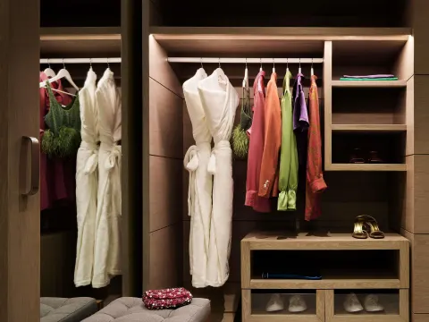 Walk-in closet with robes, clothing, shelves, and shoes at SLS Playa Mujeres.