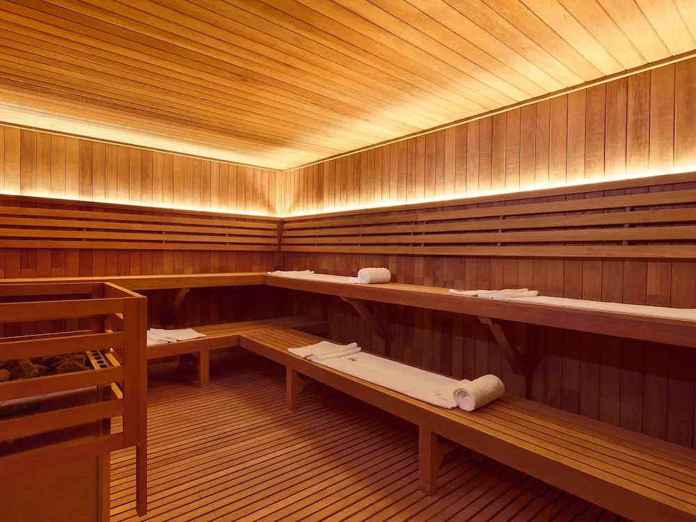 Wood-lined sauna with benches and towels at SLS Playa Mujeres.