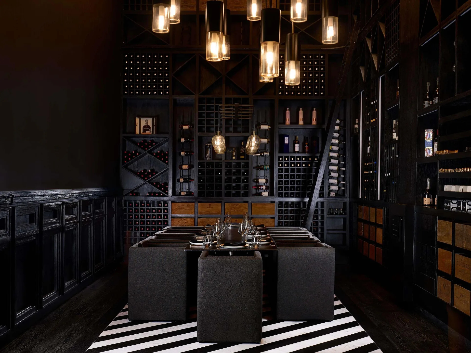 Dark private wine dining room with wall racks at SLS Playa Mujeres.