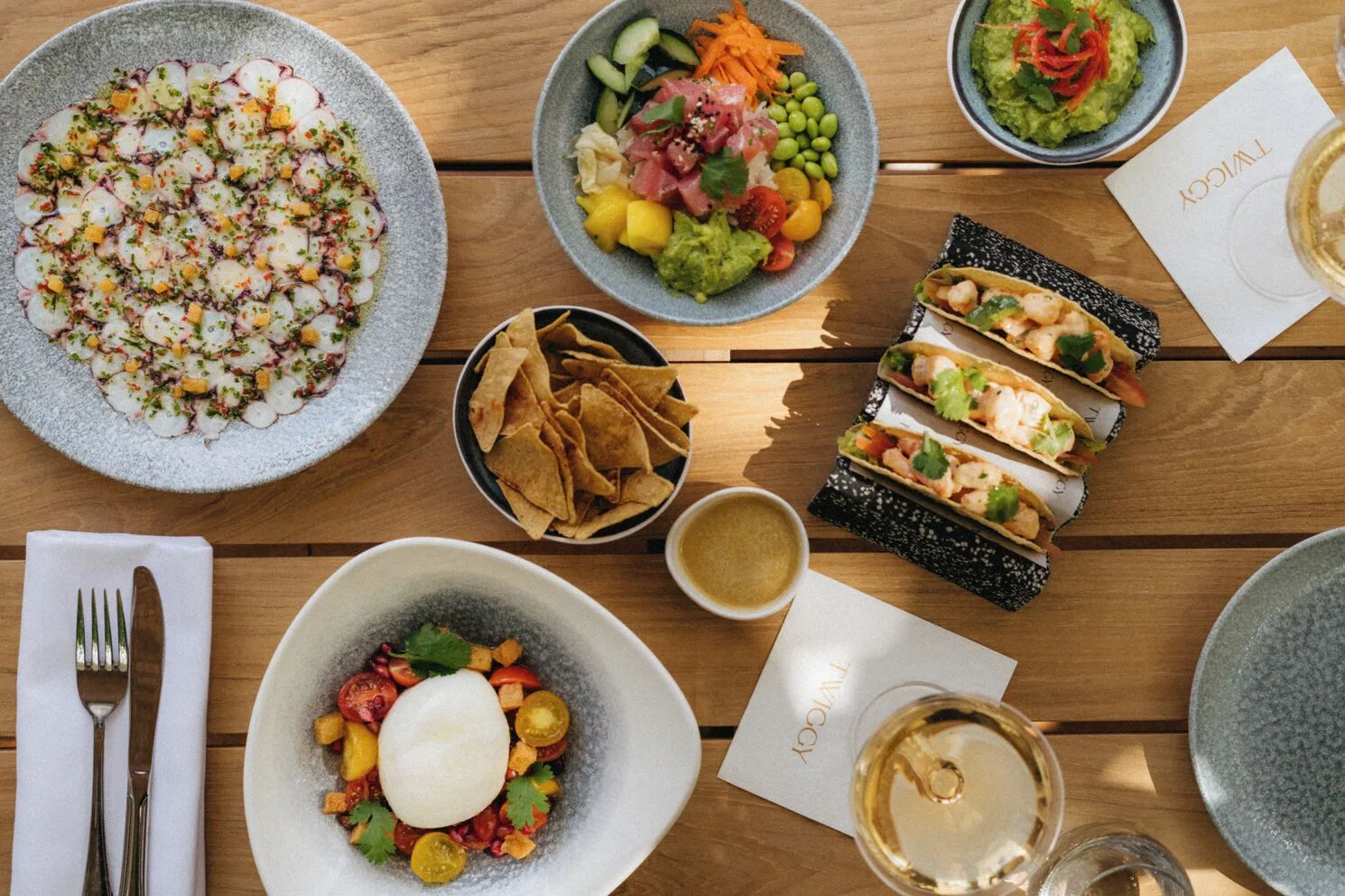 Seafood, chips, guacamole, tacos, and drinks are arranged on a table at SLS Playa Mujeres.
