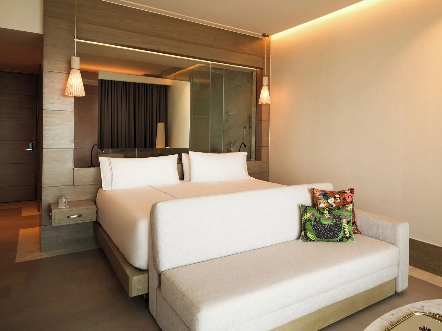 Delight guest room king bed and sofa at SLS Playa Mujeres.