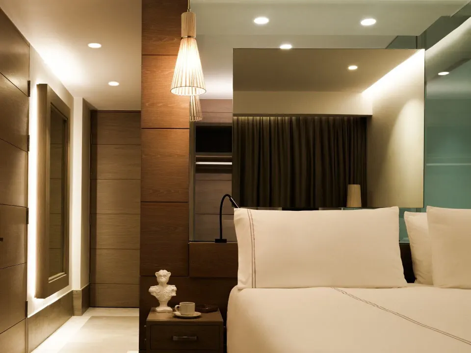 Delight guest room bed and mirrored wall at SLS Playa Mujeres.