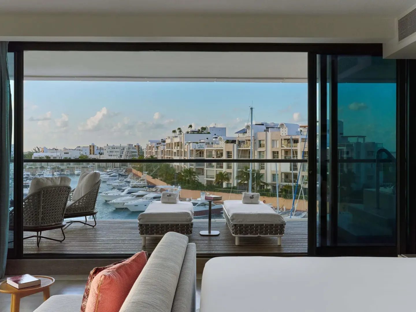 Euphoria Corner Suite Marina View balcony loungers beside the bed at SLS Playa Mujeres.
