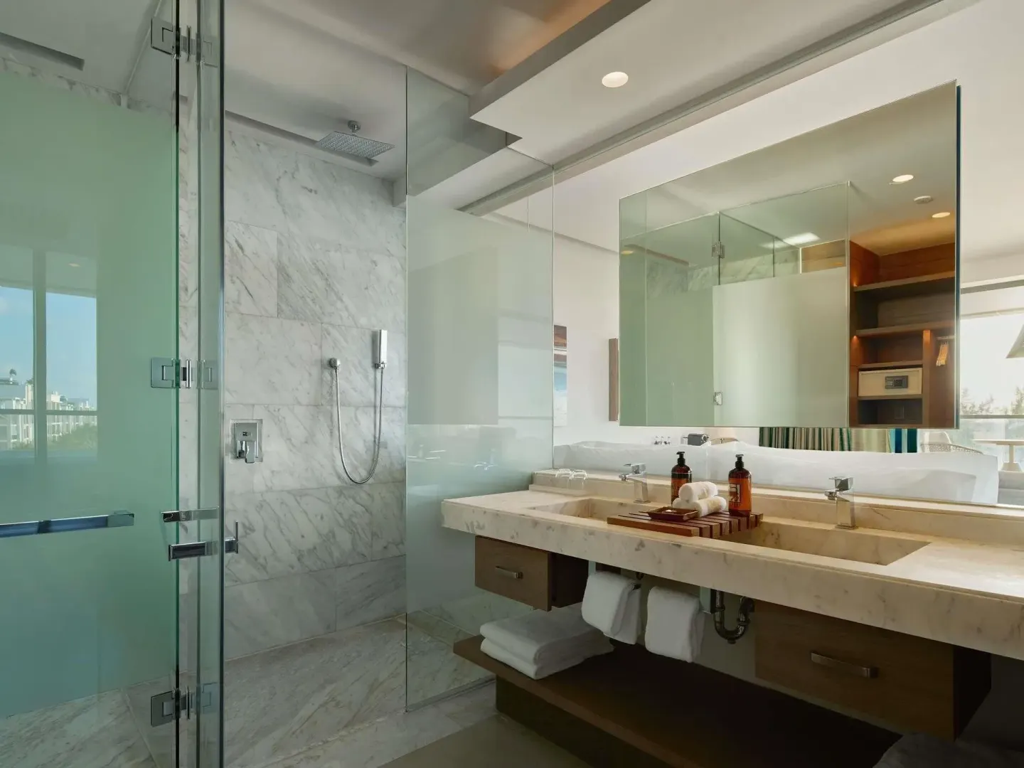 Euphoria Suite bathroom with glass shower and double vanity at SLS Playa Mujeres.