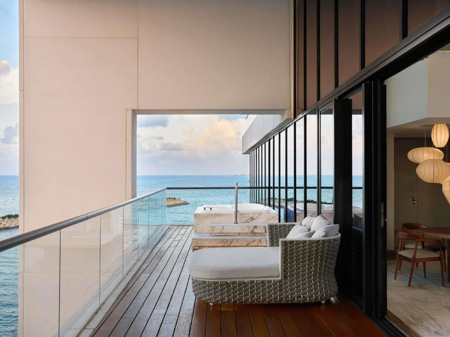 Balcony daybed and marble plunge tub overlooking the sea at SLS Playa Mujeres.