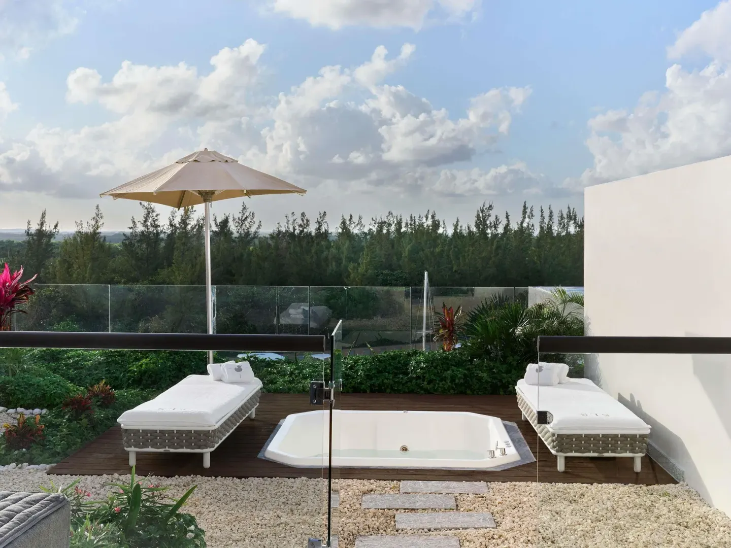 SLS Playa Mujeres terrace with soaking tub and loungers at SLS Playa Mujeres.