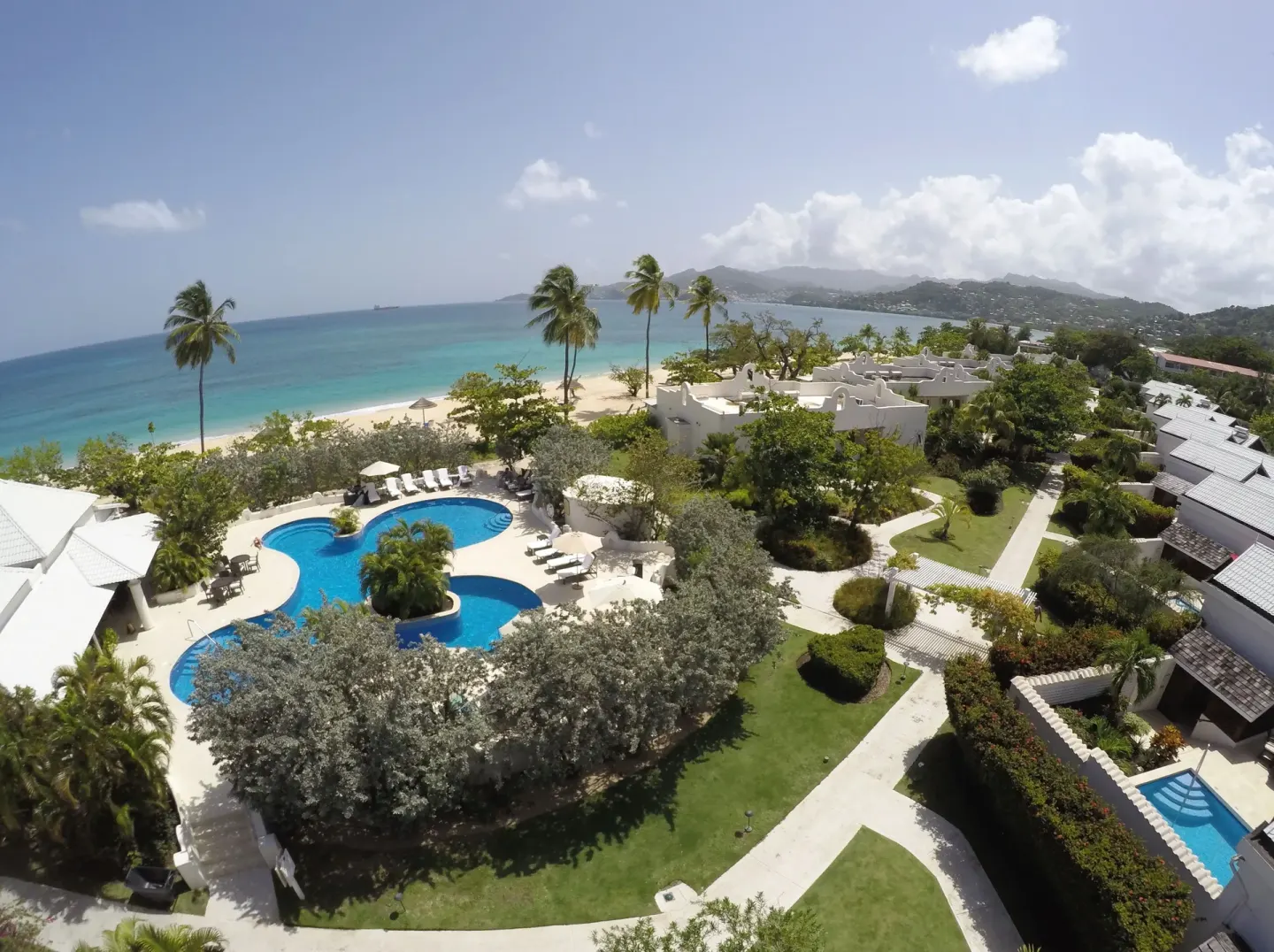Aerial view of the pool, gardens and beachfront at Spice Island Beach Resort.