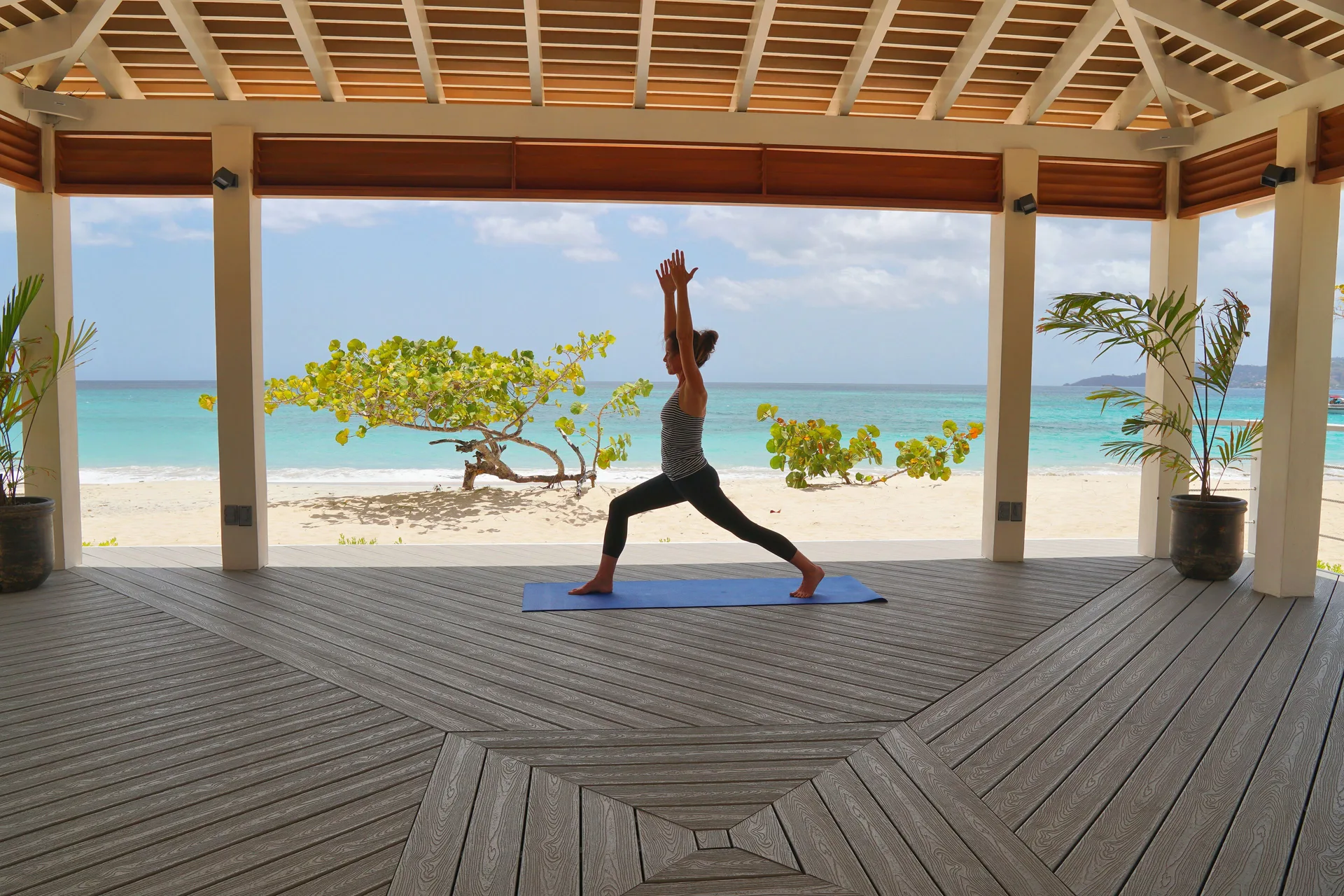 Yoga on a beach pavilion deck overlooking the sea at Spice Island Beach Resort.