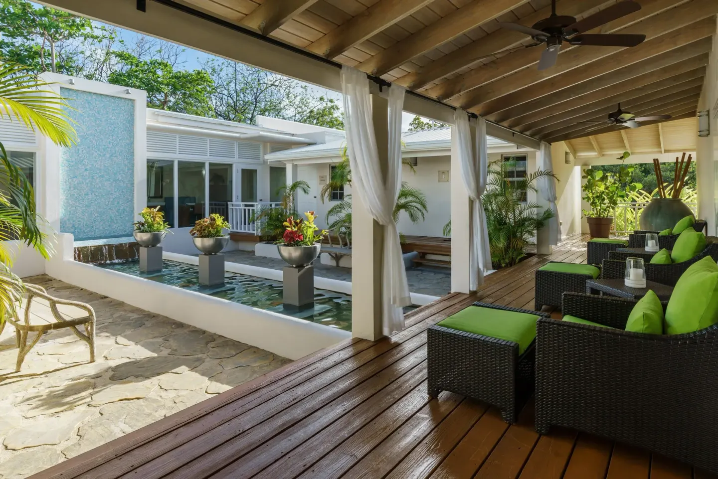 Covered lounge terrace beside a courtyard pool at Spice Island Beach Resort.
