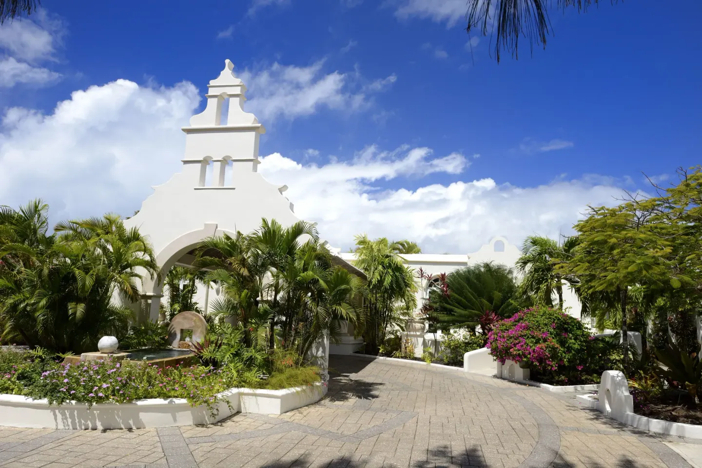 White arched entrance and tropical gardens at Spice Island Beach Resort.