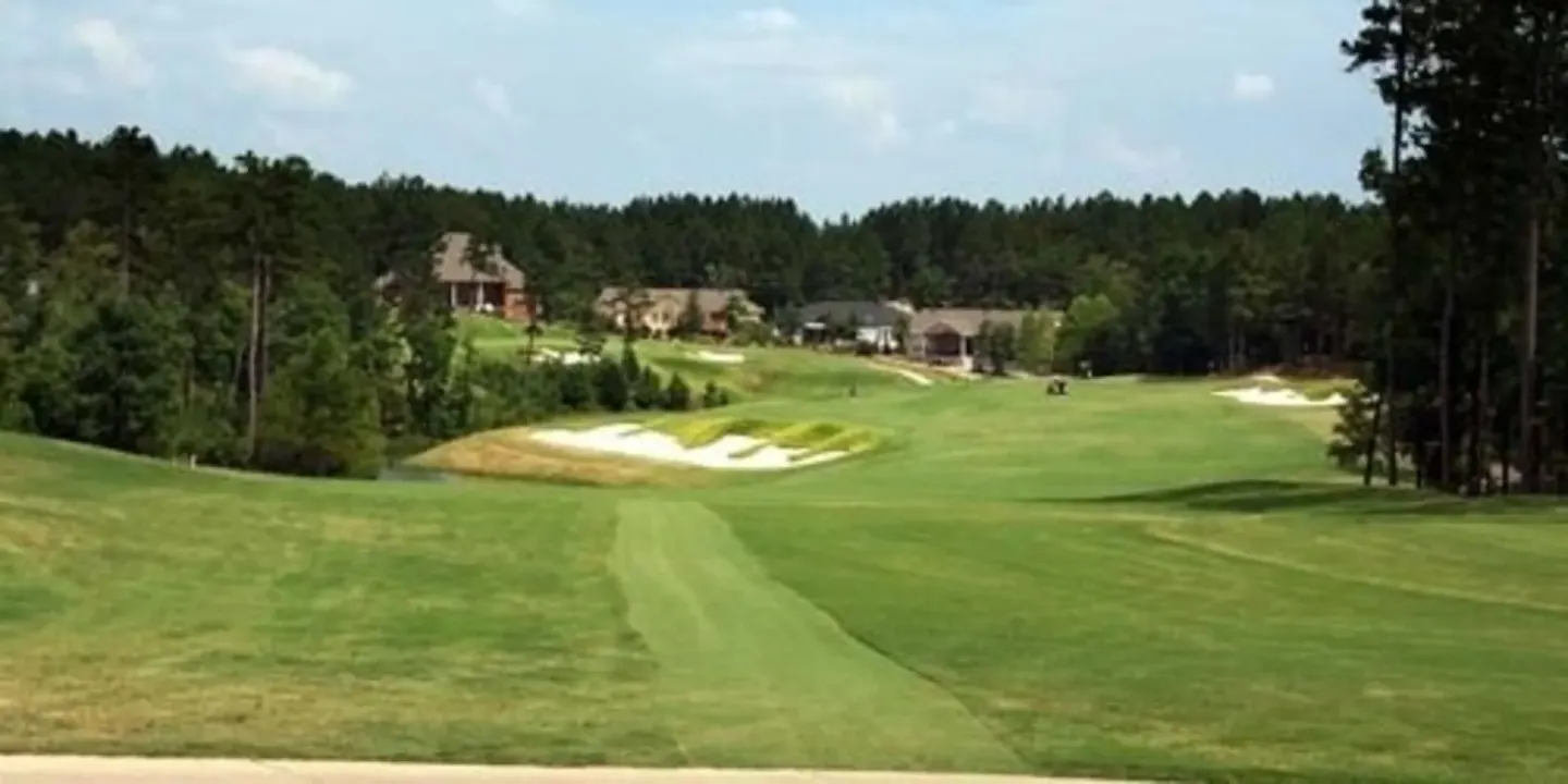 A green golf fairway with sand bunkers near Spice Island Beach Resort.