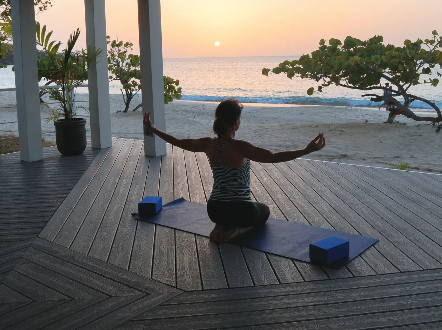Seated sunset yoga on a beach deck at Spice Island Beach Resort.