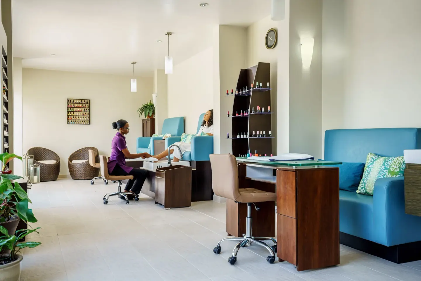 A guest receives a pedicure beside blue spa benches at Spice Island Beach Resort.
