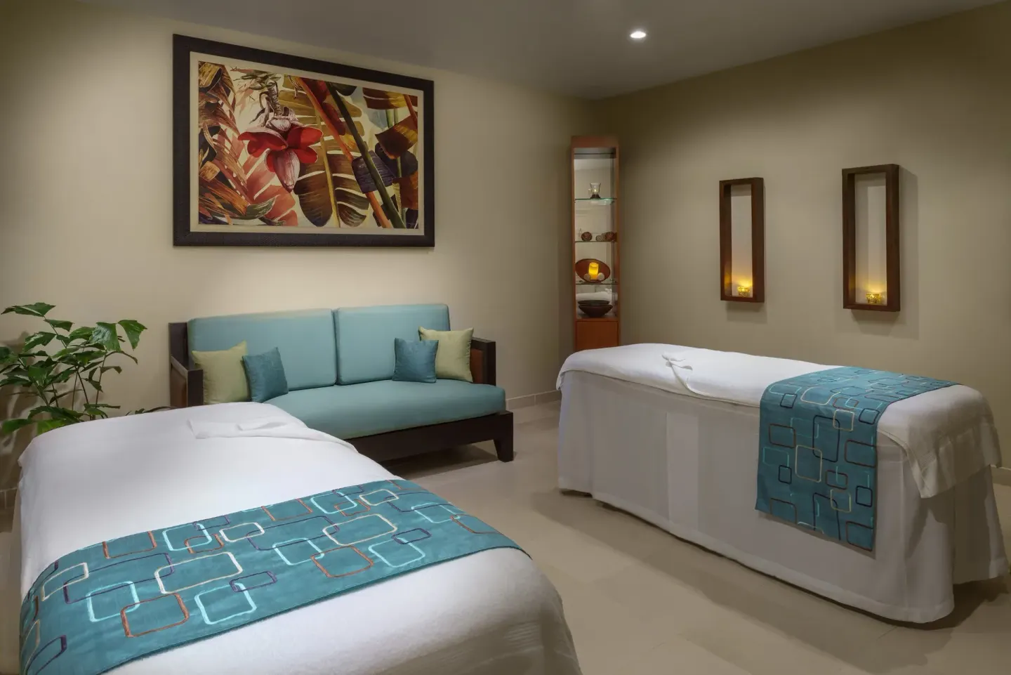 Two treatment beds and a blue sofa in the spa at Spice Island Beach Resort.