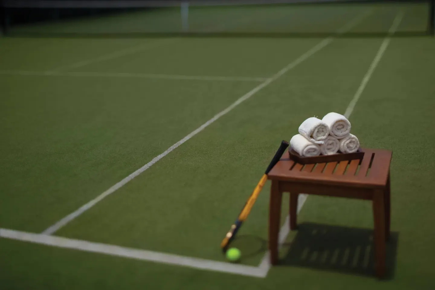 Tennis court with towels and a racket at Spice Island Beach Resort.