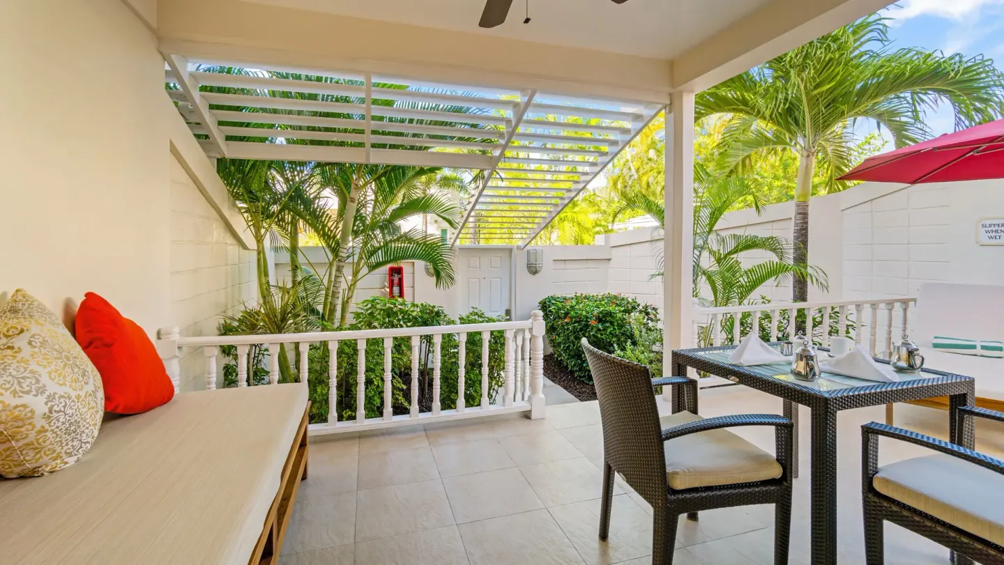 Covered Anthurium Pool Suite patio with dining table at Spice Island Beach Resort.