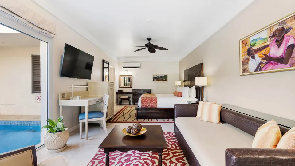 Anthurium Pool Suite with bed, sofa, desk, and private pool at Spice Island Beach Resort.