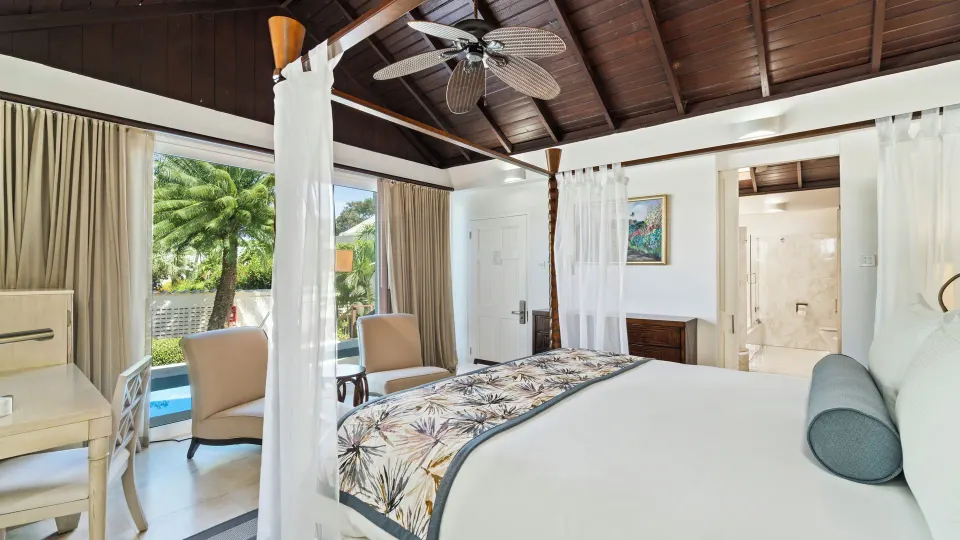 Luxury Almond Pool Suite bedroom with four-poster bed at Spice Island Beach Resort.