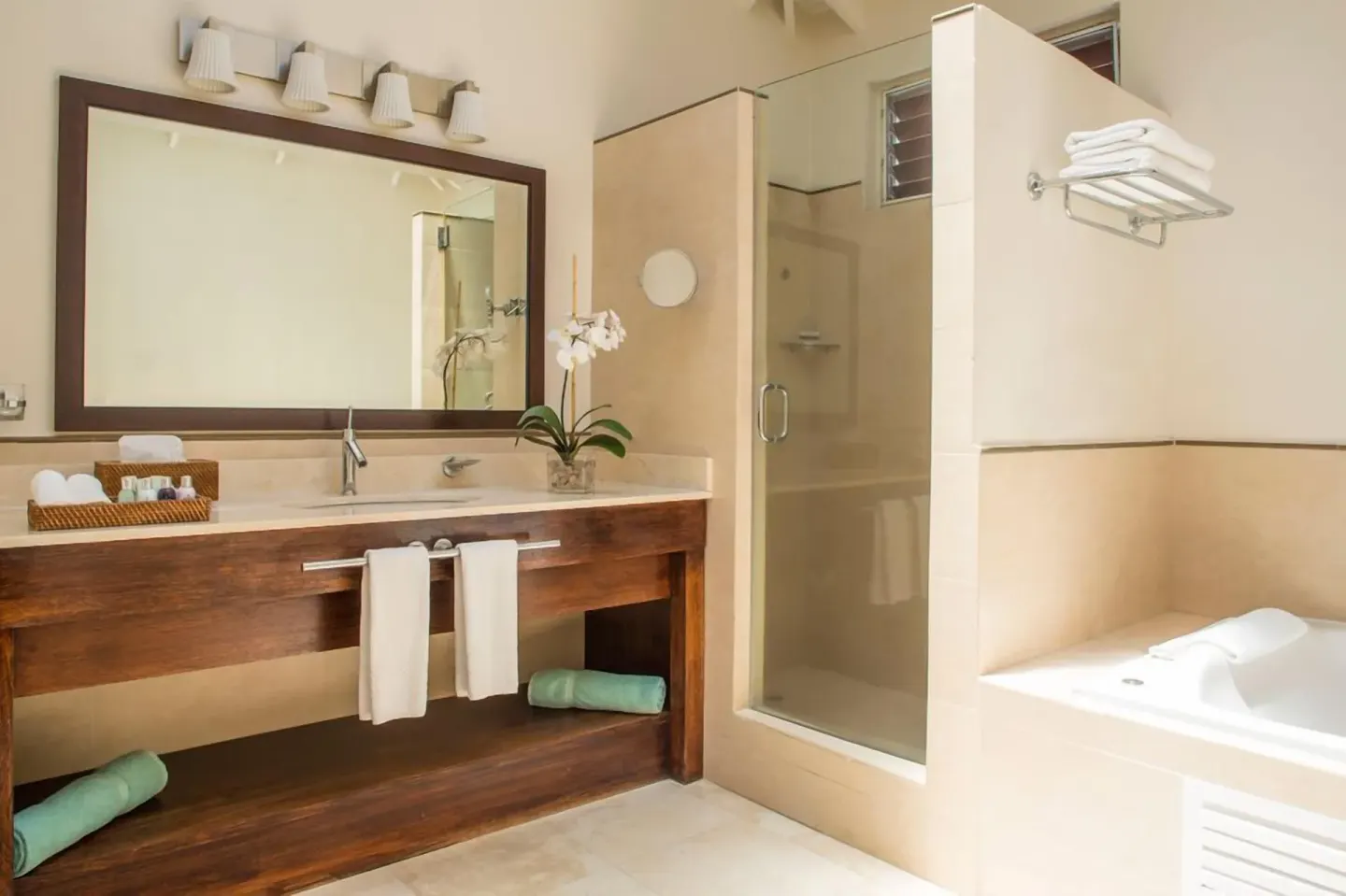 Oleander Garden Suite bathroom with vanity, shower, and tub at Spice Island Beach Resort.