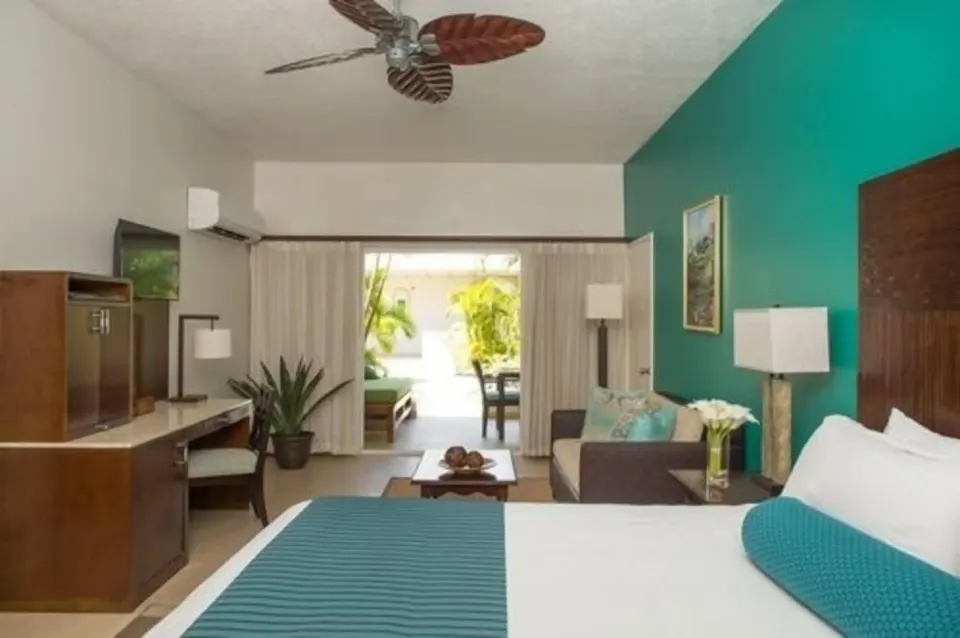 Oleander Garden Suite bedroom with sitting area at Spice Island Beach Resort.