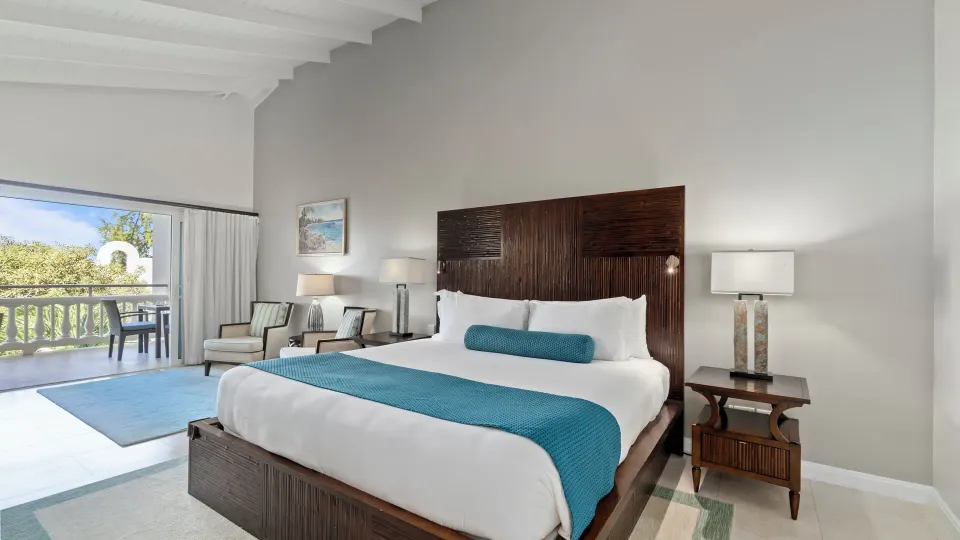 Oleander Garden View Suite king bed and balcony at Spice Island Beach Resort.