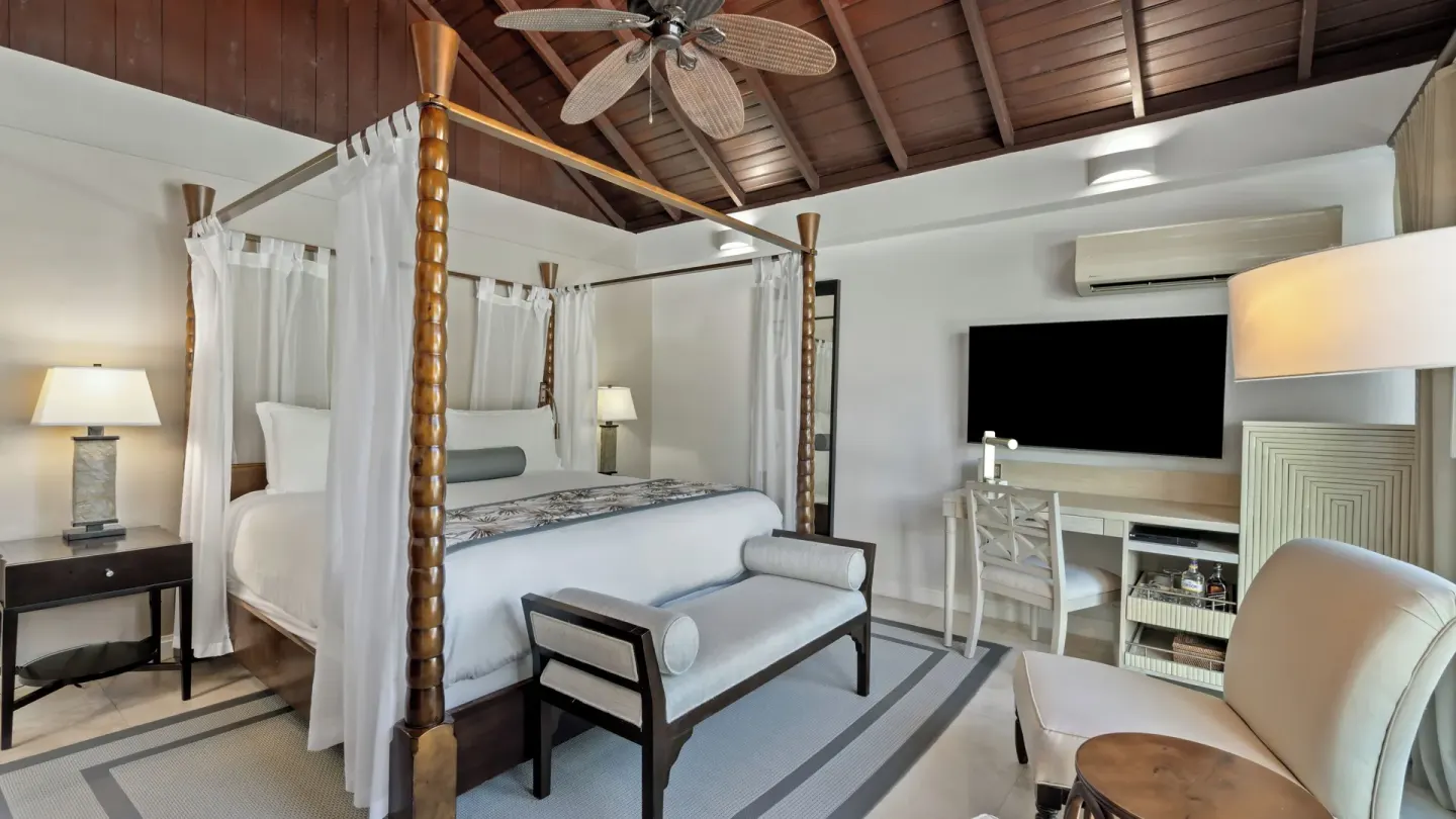 Royal Collection Pool Suite bedroom with four-poster bed at Spice Island Beach Resort.