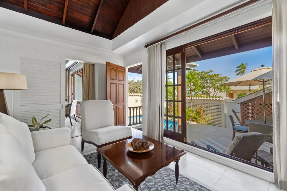 Royal Collection Pool Suite sitting area opening to the pool patio at Spice Island Beach Resort.