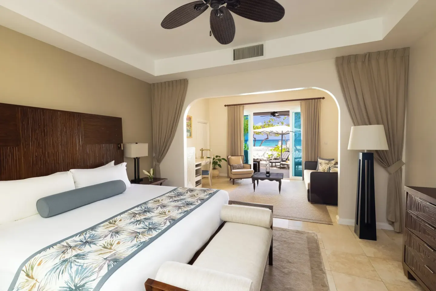 Seagrape Beach Suite king bed and sitting area at Spice Island Beach Resort.