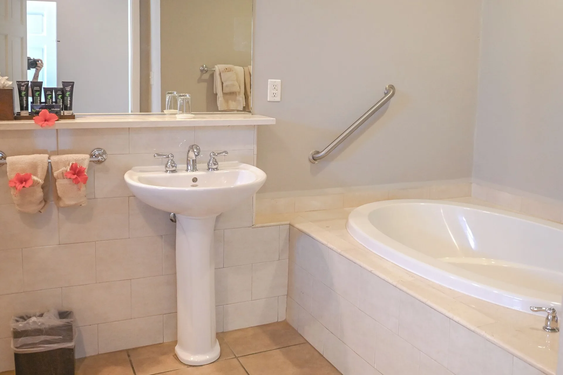Bathroom with pedestal sink, mirror, soaking tub and towels at St. James's Club Antigua.