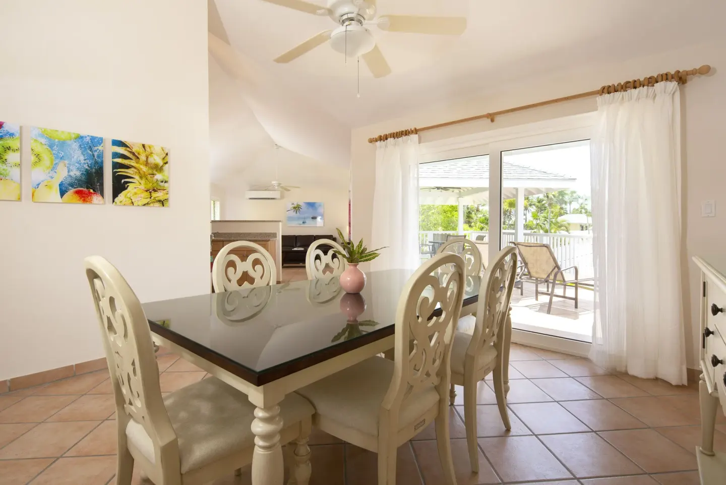 Dining area with glass-top table and balcony doors at St. James's Club Antigua.