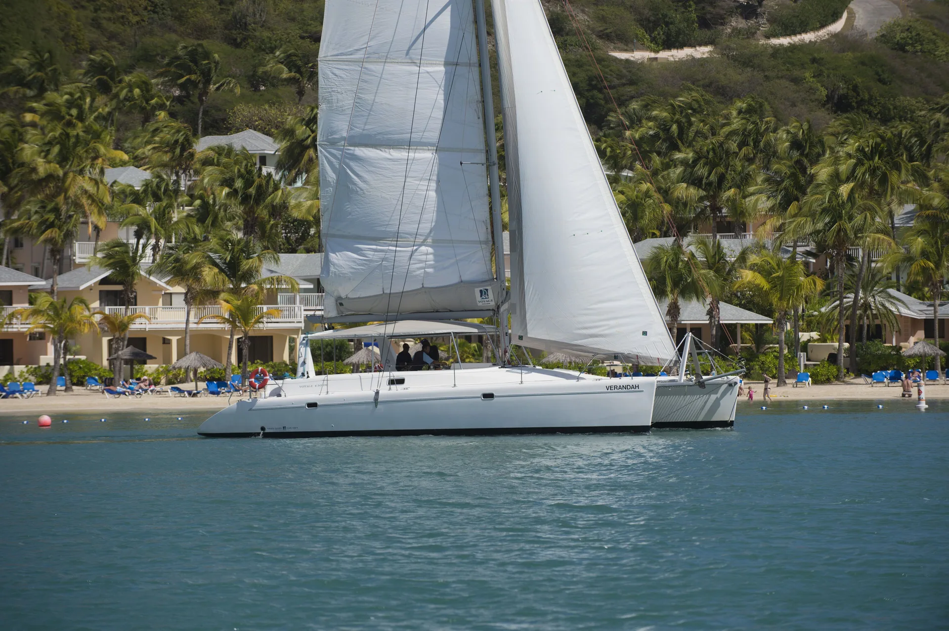 White sailing catamaran offshore from the beach at St. James's Club Antigua.